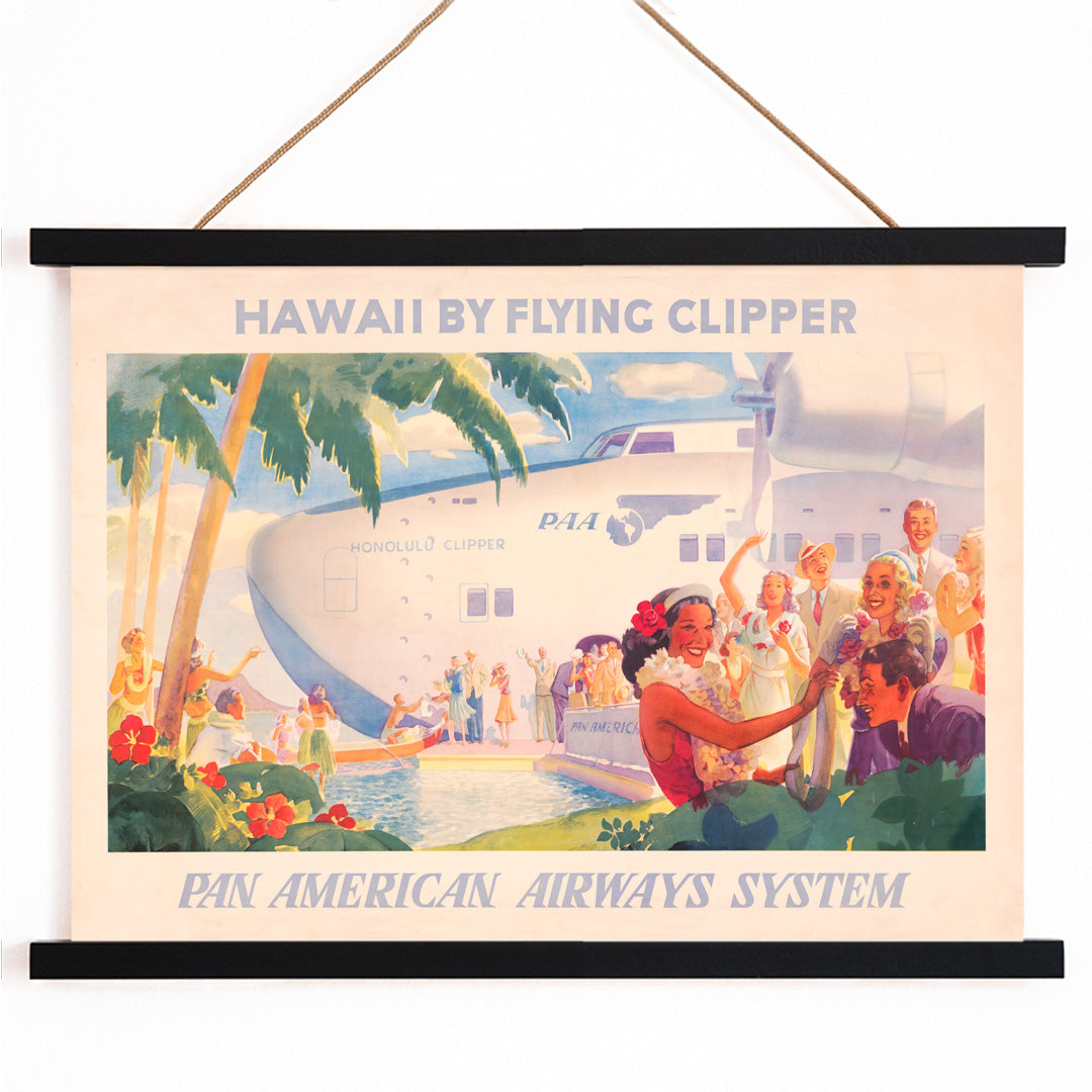 Vintage travel poster of Pan American Airways seaplane in Hawaii with people greeting each other with leis and Hawaiian welcome scene, with wooden magnetic frame on white background