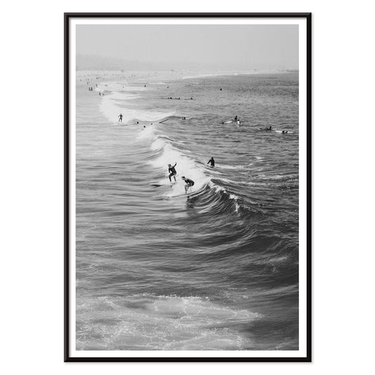 Black and white surfers riding waves at Venice Beach coastal wall art poster ideal for home decor, with black aluminium frame on white background