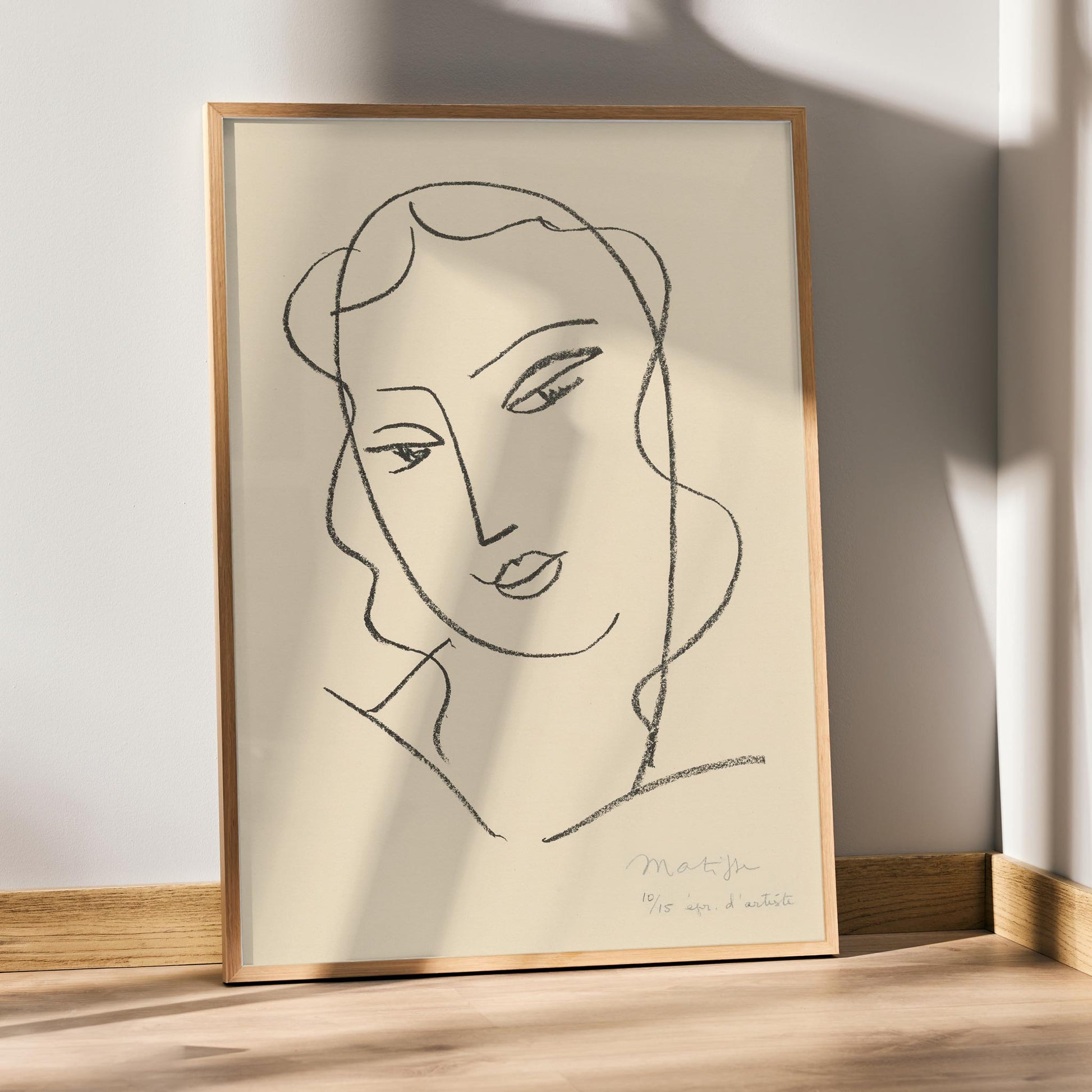 Henri Matisse Veiled Head poster with minimalist veiled face in black linework on a warm pale background, framed and displayed in modern living room decor