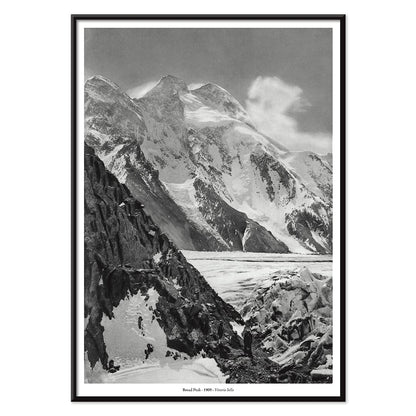 Black and white photograph and poster of Broad Peak by Vittorio Sella showing snow covered mountains and mountaineers climbing amidst rocky terrain and glacier, with black aluminium frame on white background