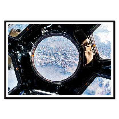 Earth view from International Space Station cupola by NASA with planet visible below poster artwork, with black aluminium frame on white background