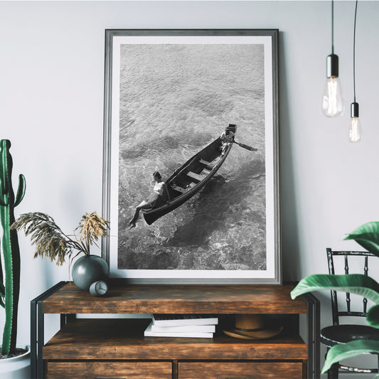 Fashion model on boat edge with man rowing in clear water Montego Bay Jamaica by Toni Frissell artwork poster, framed and displayed in home decor