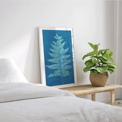Fern Cianotipia botanical cyanotype artwork by Anna Atkins showing a detailed fern against a blue background poster, framed and displayed in home decor
