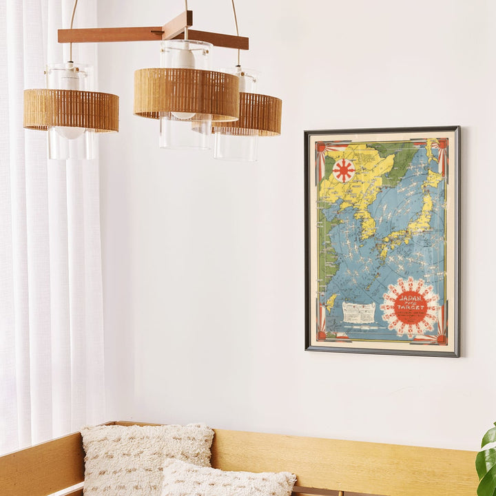 Colorful illustrated map of Japan and surrounding regions by Ernest Dudley Chase titled Japan the Target a Pictorial Jap-map poster, framed and displayed in modern living room decor