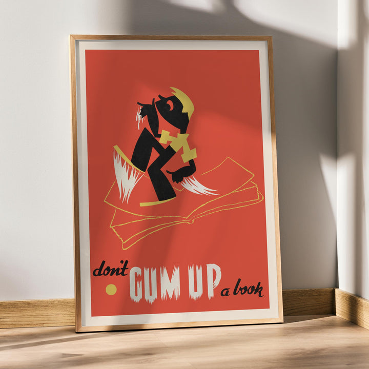 Arlington Gregg Dont gum up a book poster with bold black figure over open book on red background with yellow accents, framed and displayed in modern living room decor