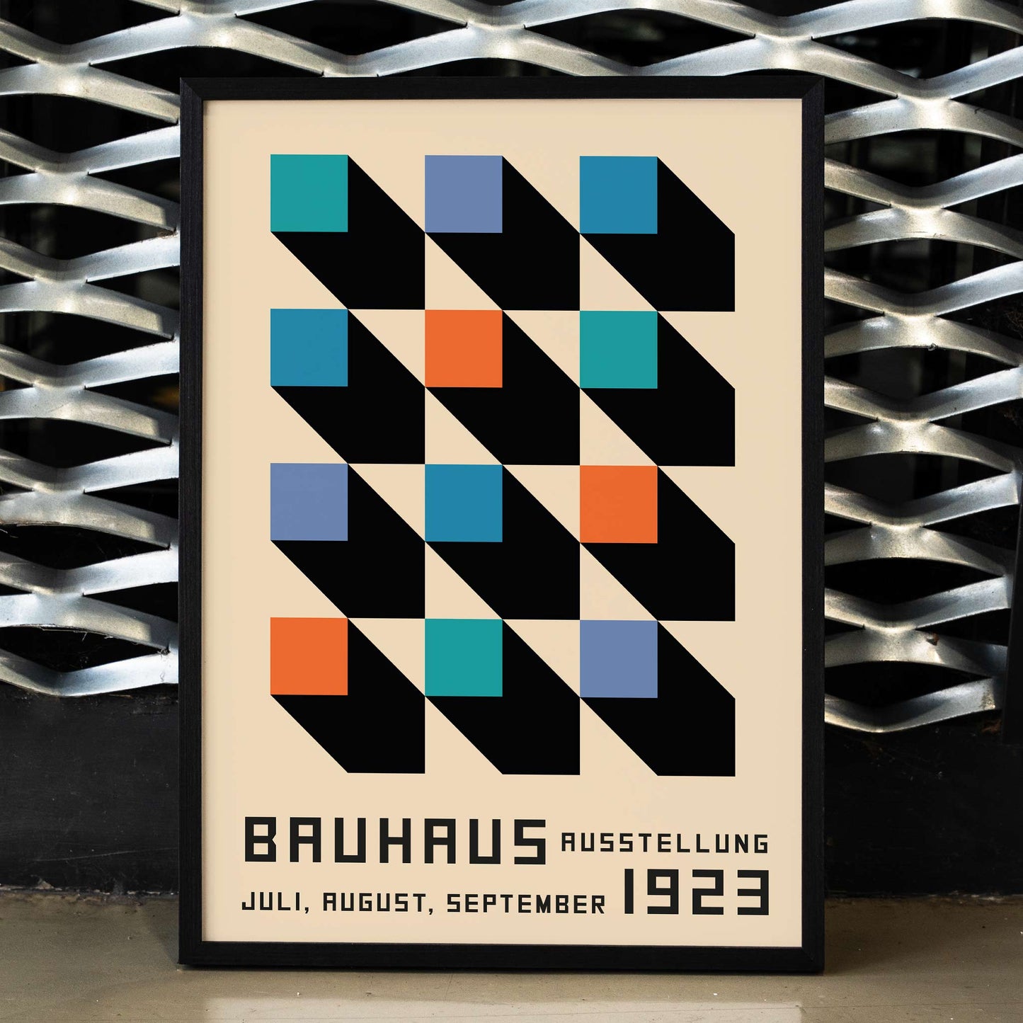 Bauhaus Poster inspired by the Weimar Exhibition with geometric patterns bold colors by Joost Schmidt in black blue orange and teal squares, framed and displayed in home decor