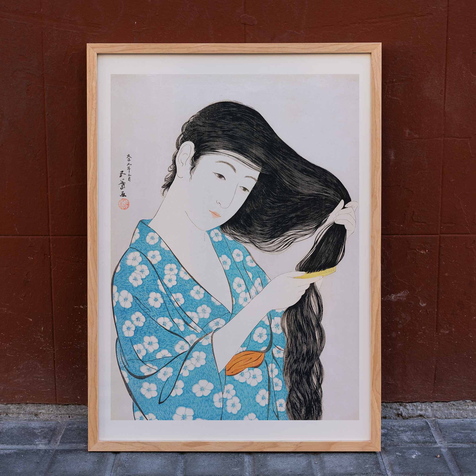 Woman in blue floral kimono combing her long hair artwork Woman Combing Her Hair by Goyo Hashiguchi Japanese art poster, framed and displayed in home decor