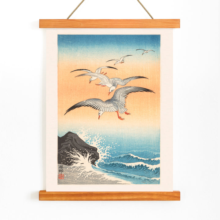 Five seagulls flying over turbulent sea with waves and rocky shore artwork by Ohara Koson, with wooden magnetic frame on white background