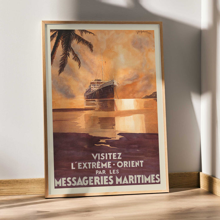 Visit the Far East by Messageries Maritimes poster with ship on calm water at sunset, palm silhouettes, maritime travel style, framed and displayed in modern living room decor