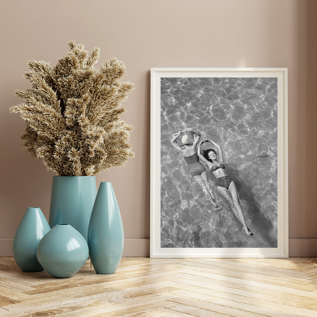 Fashion models in vintage bathing suits floating in a swimming pool artwork by Toni Frissell, framed and displayed in home decor