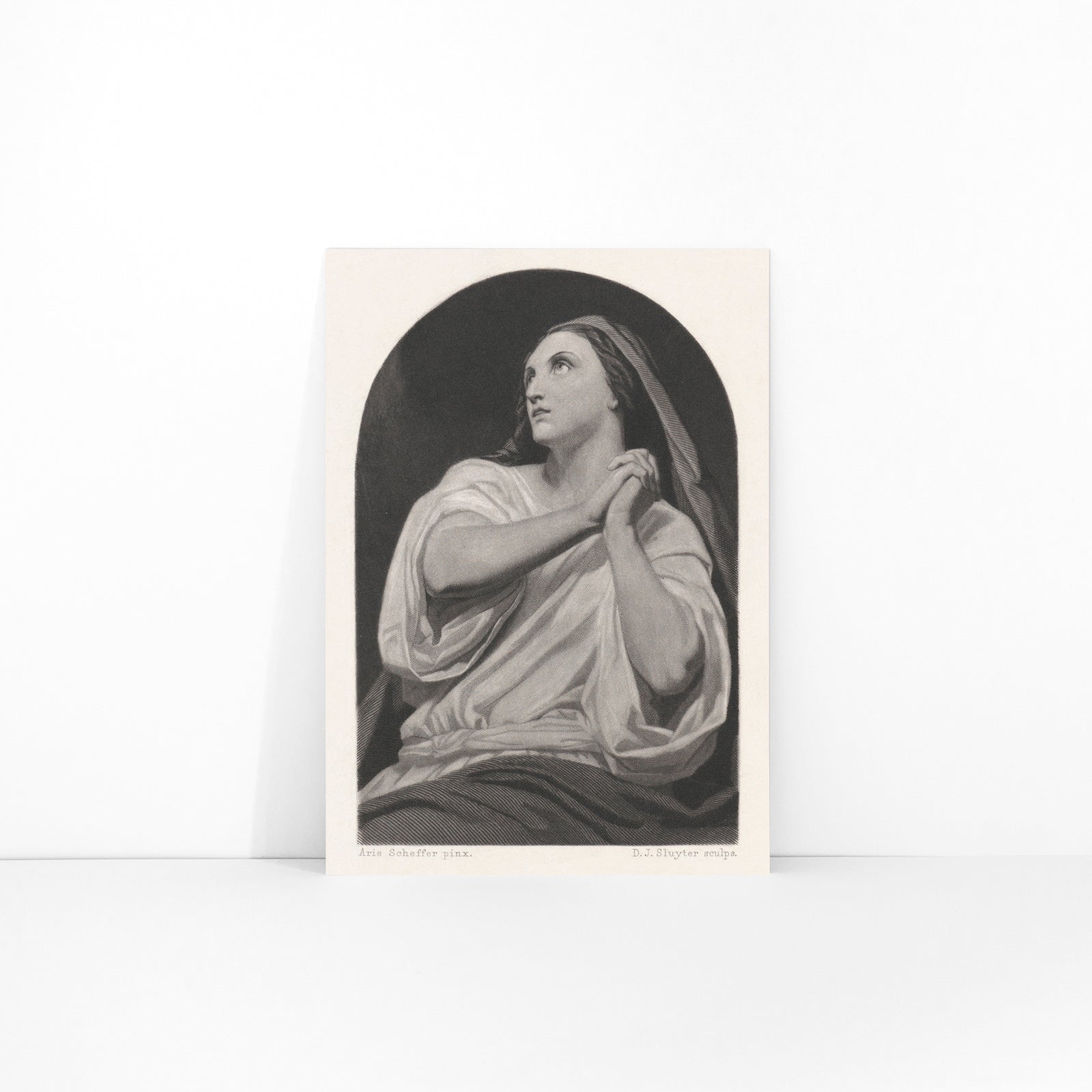 Black and white artwork of a praying woman with folded hands and serene expression by Dirk Jurriaan Sluyter, framed and displayed in modern living room decor